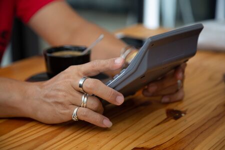 businessman hands searching for data on mobile phone with analyzing charts at his workplace.の写真素材