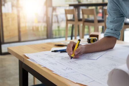 Engineer man and Architect drawings blueprint  at Construction Site.Home Project to Offer Management