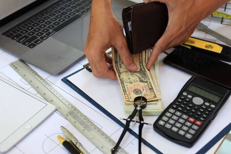 Hand Engineers are counting the money received from the design on the construction site.の写真素材