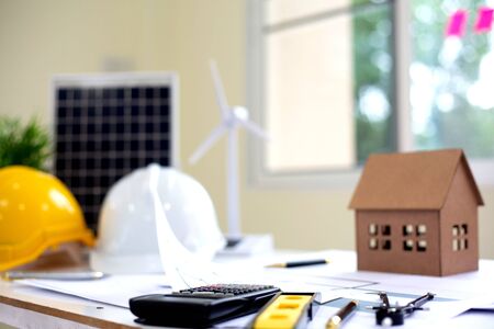 Desk of Architectural working solar panel home project in construction site,With drawing equipment concept.の写真素材