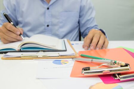Business man using calculator and holding money for calculate tax in office.の写真素材
