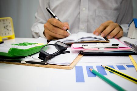 Business man using calculator and holding money for calculate tax in office.