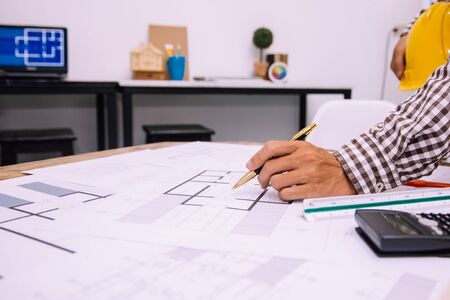 Engineer man and Architect drawings blueprint at Construction Site.Home Project to Offer Management
