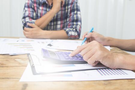 Team businessman using calculator  for calculate tax.financial  plan and analyzing investment charts...