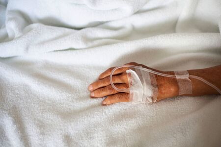hand of the patient who is receiving the saline solution in the room of the patient in the hospital who is suffering from diarrhea.の写真素材