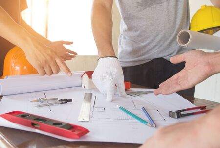 team Engineer and Architect consult projct with blueprint  at Construction Site