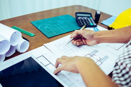 Engineer man and Architect drawings blueprint at Construction Site.Home Project to Offer Management