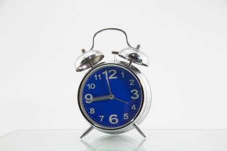 An alarm clock placed on a white backgroundの写真素材