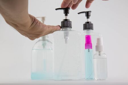 man's hand was pressing a bottle of alcohol to wash his hands to prevent Kovid 19 on a white background.の写真素材