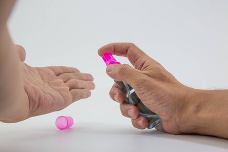 man's hand was pressing a bottle of alcohol to wash his hands to prevent Kovid 19 on a white background.の写真素材