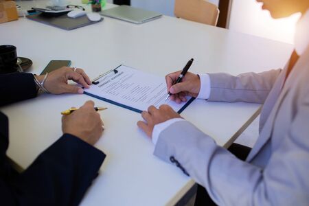 Business people are signing a joint venture agreement for a new projectの写真素材