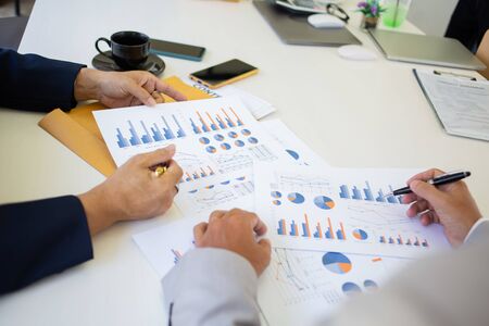 business team hands searching for data on mobile phone  with analyzing charts at his workplace.の写真素材