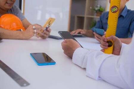 group of business Engineer hands searching for data on mobile phone  with analyzing charts at his workplace.の写真素材