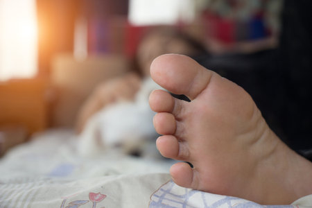 Close up of a woman's foot on the bed with her dog