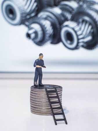 Miniature people engineer standing on coins, Success people miniature business