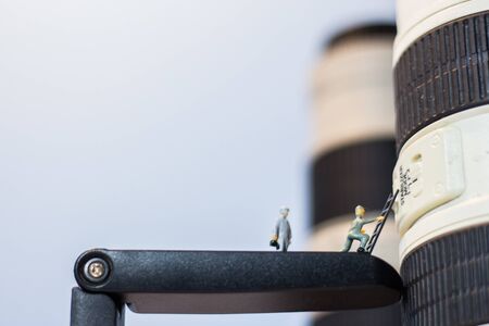 Miniature people checking the lens of the camera.の写真素材