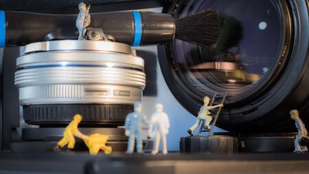 Miniature people checking the lens of the camera.の写真素材