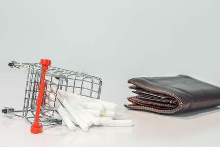 Close up cigarette on mini shopping cart on white background  with copy specsの写真素材