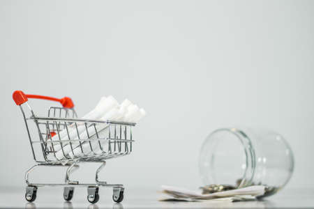 Close up cigarette on mini shopping cart on white background  with copy specsの写真素材