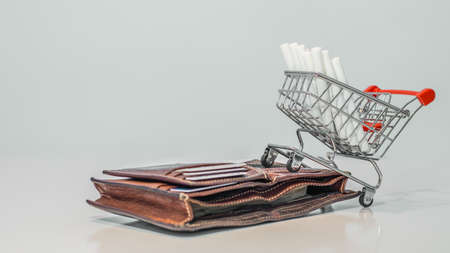 Close up cigarette on mini shopping cart on white background  with copy specsの写真素材