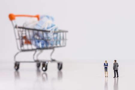 Miniature people : Business men stand and look at the used medical maskの写真素材