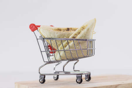 Tuna mayonnaise sandwich on mini shopping cart on white background with copy specsの写真素材