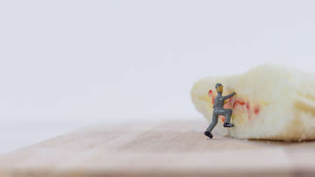 Miniature people team checks the quality of sandwich bread on white backgroundの写真素材