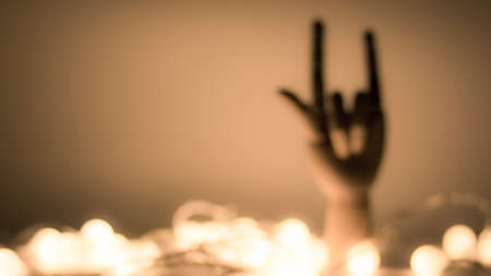 Silhouette of wooden hand with golden blurred lights backgroundの写真素材