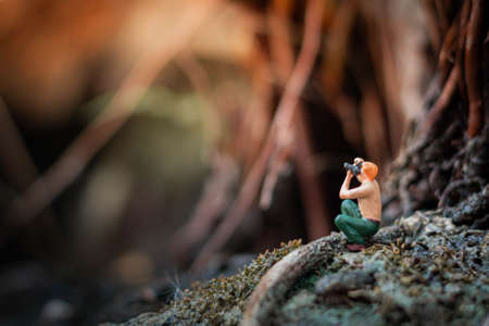 Miniature photographer taking photo of beautiful landscapeの写真素材