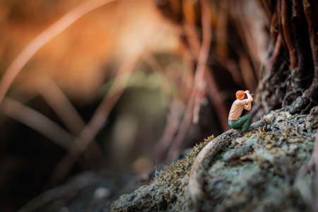 Miniature photographer taking photo of beautiful landscapeの写真素材