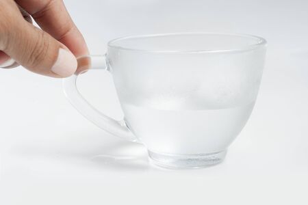 hand hold glass of water, glass has water and bubbles in the water in a white backgroundの写真素材