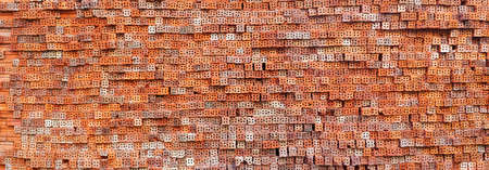 red brick wall pattern for blank background, red-brown bricks pile is waiting for constructionの写真素材