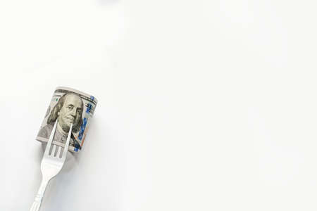 US banknotes skewered on fork in white backgroundの写真素材