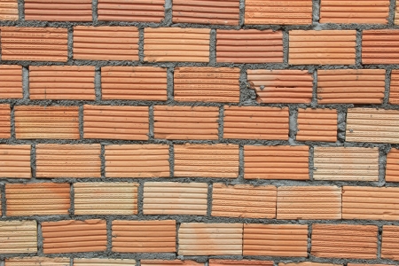 A damaged old brick wall with major cracks and splits の写真素材