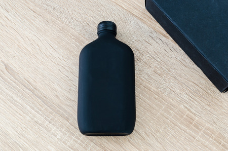 black bottle and  black box on wood backgroundの写真素材