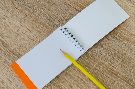Note book and pencil on wood table