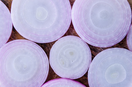 sliced shallots on wood background ,top viewの写真素材