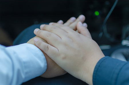 Romantic couple with soft clasped hands closeup conceptual image of love