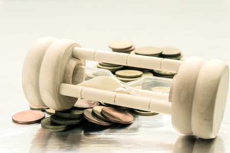 Hourglass on coins currency, sandglass. Deadline and time is money conceptの写真素材