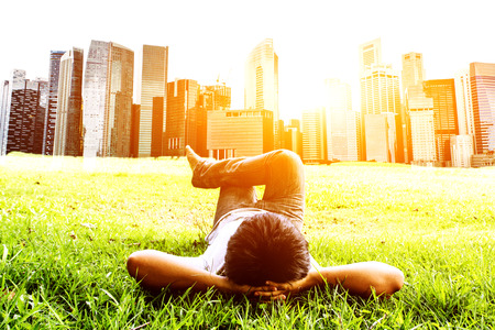 Young hipster man ralax on green grass in parkの写真素材