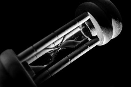 Hourglass on black background. Concept deadline time.の写真素材