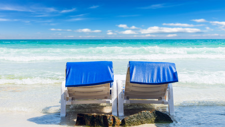 Summer vacation background. deckchairs on white sand beach and ocean sea. Travel and relax with...