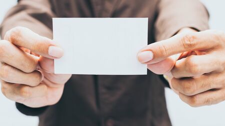 Businessman holding bank mockup business card on white background.