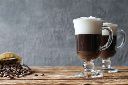 Two Irish coffees with coffee beans on the tableの写真素材