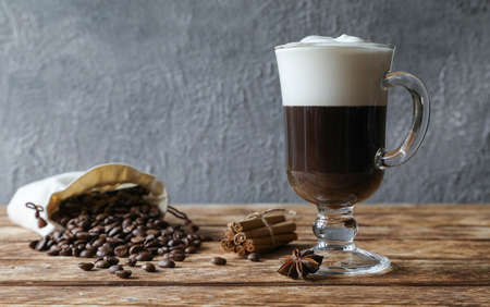 Irish coffee with cinnamon, star anise and coffee beans on a wooden tableの写真素材