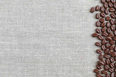 Chocolate coffee beans on a textile background with copy space - top viewの写真素材