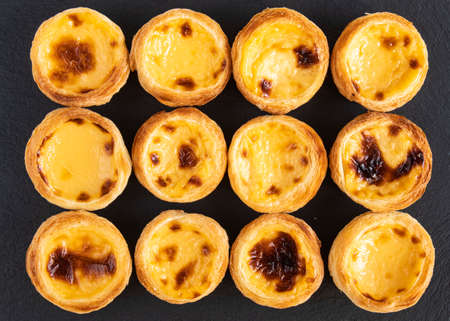 Pastel de nata - traditional pastries from Portugal, consisting of egg yolk, flour, milk, water, icing sugar - a beautiful background of a Portuguese dessert, top viewの写真素材