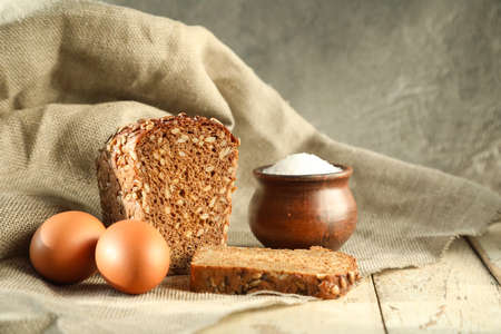 Traditional Russian breakfast-black bread with cereals and boiled eggs with a pot of salt with a lid...