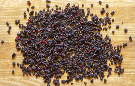 Dried berries of currants and dried blueberries on a wooden table. Ecologically clean food. Healthy dried berries of blueberries and currants.の写真素材