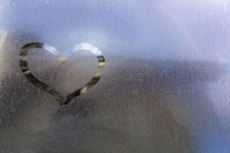 Draw the heart on vapor at the glassの写真素材